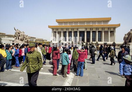 Touristes et sur la gauche dans la photo un homme en uniforme devant le mausolée Mao Zedong à Beijing. [traduction automatique] Banque D'Images