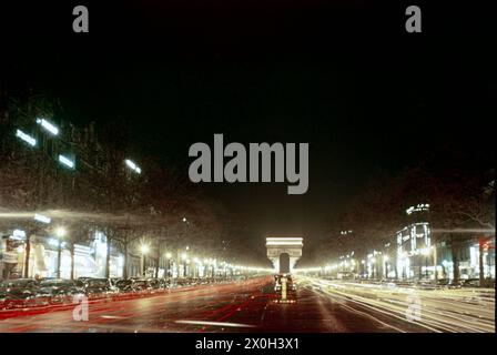 L'avenue des champs-Elysées à Paris la nuit avec des rayures claires. En arrière-plan, on peut voir l'Arc de Triomphe. Banque D'Images