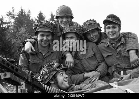 Lors d'un exercice militaire du II corps des forces armées allemandes dans l'Alb souabe, une troupe de soldats joyeux en uniforme pose pour la caméra. Ils portent des costumes de campagne et des casques de combat. Une mitrailleuse est visible sur le bord gauche de l'image. [traduction automatique] Banque D'Images