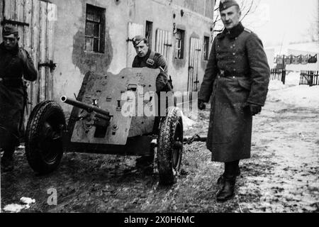 Les soldats de la Wehrmacht tiennent un canon antichar Pak 36 de 3,7 cm en position près d'une grange en France. La photo a été prise par un membre du 154e régiment d'infanterie / 58e division d'infanterie, en France. [traduction automatique] Banque D'Images