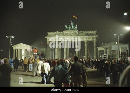 Foule sur la place devant la porte de Brandebourg le premier Noël après la chute du mur de Berlin. [traduction automatique] Banque D'Images