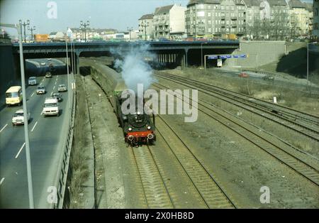 Le train spécial conduit par la locomotive à vapeur de classe 38 1183 passe juste sous le pont Kaiserdamm parallèle à la Ringbahn [traduction automatique] Banque D'Images