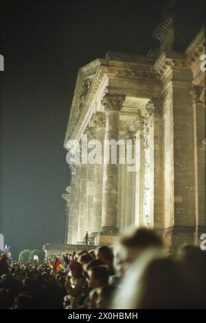 Une foule célèbre la réunification allemande devant le Reichstag à Berlin dans la nuit du 3 octobre. [traduction automatique] Banque D'Images