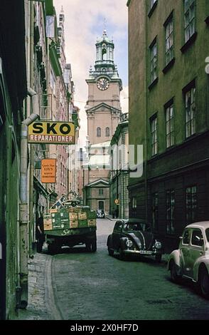 Des voitures et un véhicule de livraison dans la ruelle étroite TrÃ¢ngsund, qui mène à Storkyrkan, également connu sous le nom de Sankt Nikolai kyrka. [traduction automatique] Banque D'Images