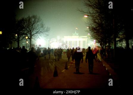 Après la chute du mur, la foule à la porte de Brandebourg a considérablement changé. Le sapin de Noël de Berlin Ouest en arrière-plan derrière la porte [traduction automatique] Banque D'Images