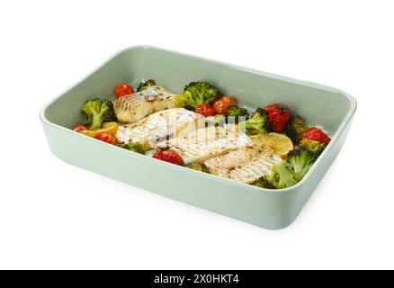 Morceaux de délicieuse morue cuite au four avec légumes, citron et épices dans le plat isolé sur blanc Banque D'Images