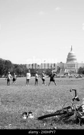 Jeunes hommes jouant au Frisbee sur la pelouse près du Capitole des États-Unis, Washington, DC, États-Unis. Banque D'Images