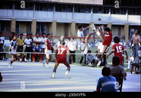 Les jeunes hommes jouent Sepak TakRAW. Ils portent des maillots. Spectateurs tout autour. [traduction automatique] Banque D'Images