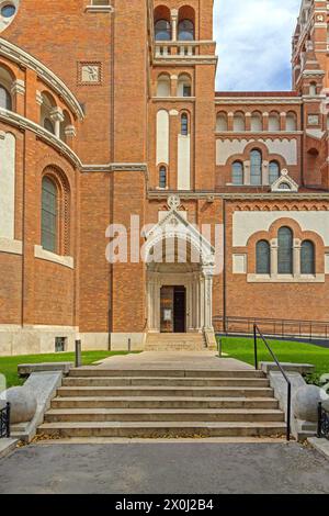 Szeged, Hongrie - 30 juillet 2022 : entrée de porte latérale du bâtiment historique de l'église votive. Banque D'Images