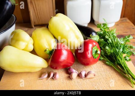 Un mélange coloré d'aliments naturels comme les poivrons, les tomates, l'ail et le persil disposés sur une planche à découper. Ces ingrédients sont essentiels dans de nombreux superaliments R Banque D'Images