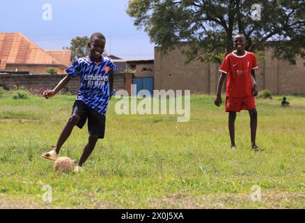 (240412) -- KIGALI, 12 avril 2024 (Xinhua) -- deux garçons jouent au football près d'une route rénovée à Kigali, Rwanda, le 9 avril 2024. Le projet d’amélioration des routes au Rwanda, confié à la China Road and Bridge Corporation (CRBC), a contribué à faciliter la circulation et à faire progresser le commerce sans faille le long du district de Kigali-Bugesera, dans l’est du Rwanda. La route rénovée, qui s’étend sur 13,8 km, part du rond-point Sonatube à Kigali, en passant par le secteur de Gahanga jusqu’au pont Akagera dans le district de Bugesera. Il fait partie d'une avenue menant au nouvel aéroport international de Bugesera au Rwanda, situé à 40 km au sud du Banque D'Images