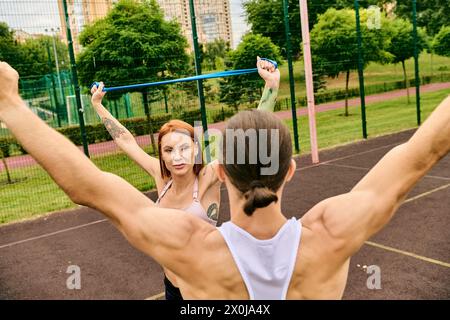 Un homme et une femme en vêtements de sport se tiennent sur un court, prêts à faire de l'exercice ensemble Banque D'Images