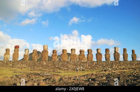 Partie arrière de l'emblématique statues Moai énormes à la plate-forme cérémonielle Ahu Tongariki avec un visiteur prenant des photos, île de Pâques, Chili, Amérique du Sud Banque D'Images