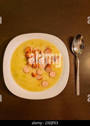 Repas chaud, soupe de pois avec saucisses de Vienne en petites tranches et morceaux servis dans une assiette Banque D'Images