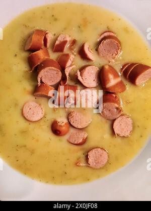 Repas chaud, soupe de pois avec saucisses de Vienne en petites tranches et morceaux servis dans une assiette Banque D'Images