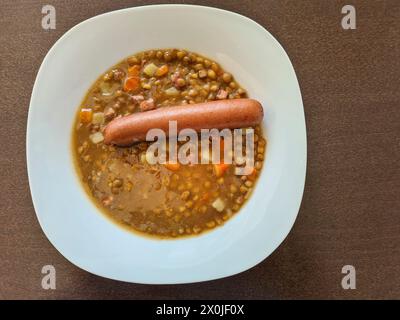 Ragoût de lentilles servi avec une saucisse comme repas chaud Banque D'Images