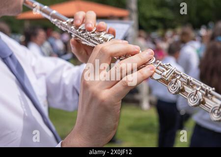 vue rapprochée des mains d'un musicien jouant d'une flûte transversale lors d'un événement en plein air Banque D'Images