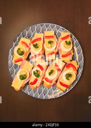 Pain tranché garni de fromage et d'oeuf, garni de persil et de paprika, servi dans une assiette, Allemagne Banque D'Images