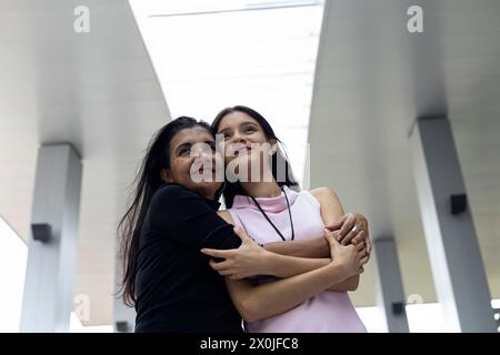 Deux femmes adultes latino-américaines mère et fille avec une attitude positive embrassent et partagent leur amour. Concept générations et fête des mères. Banque D'Images