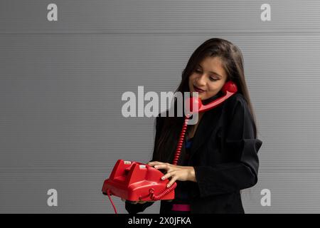 Jeune femme latino-américaine avec un casque rouge et une attitude positive, posant à la caméra. Concept de technologie jeune et vintage Banque D'Images