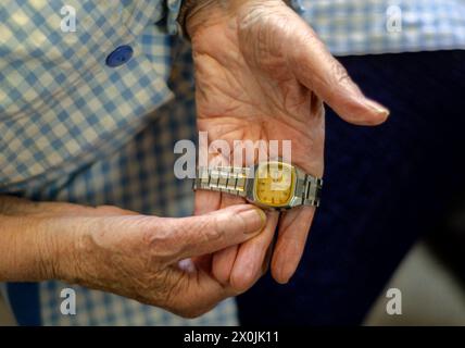 Grand-mère tenant une vieille montre dans ses mains. Concept de vieillesse, passage du temps et solitude Banque D'Images