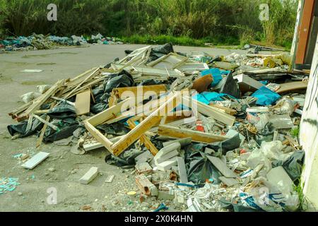 Plongez dans le paysage obsédant de la décomposition urbaine et de la dégradation de l'environnement avec cette image frappante d'une montagne de déchets dans une usine abandonnée Banque D'Images