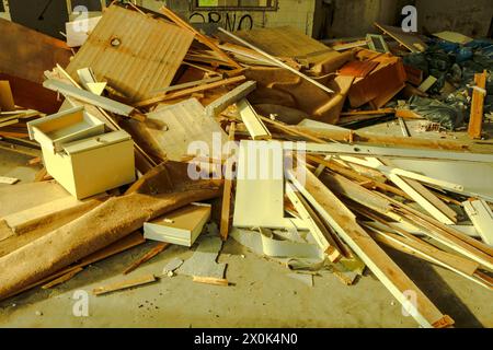 Plongez dans le paysage obsédant de la décomposition urbaine et de la dégradation de l'environnement avec cette image frappante d'une montagne de déchets dans une usine abandonnée Banque D'Images