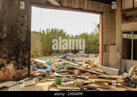 Plongez dans le paysage obsédant de la décomposition urbaine et de la dégradation de l'environnement avec cette image frappante d'une montagne de déchets dans une usine abandonnée Banque D'Images