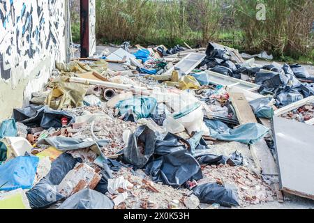 Plongez dans le paysage obsédant de la décomposition urbaine et de la dégradation de l'environnement avec cette image frappante d'une montagne de déchets dans une usine abandonnée Banque D'Images