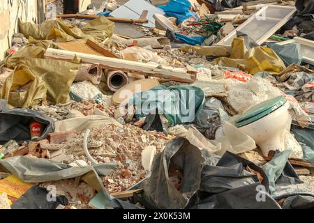 Plongez dans le paysage obsédant de la décomposition urbaine et de la dégradation de l'environnement avec cette image frappante d'une montagne de déchets dans une usine abandonnée Banque D'Images