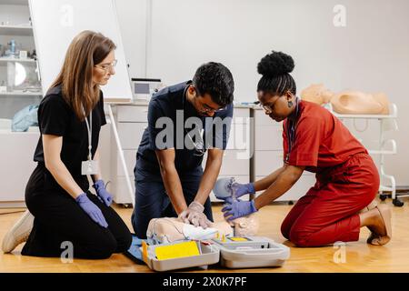 Plusieurs personnes se sont rassemblées dans une salle, participant activement à une tâche ou un événement partagé, avec des expressions et des gestes ciblés. Banque D'Images