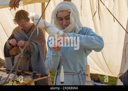 Angleterre, East Sussex, bataille, festival annuel de reconstitution de la bataille de Hastings en octobre, Woman in Medieval Costume Spinning Wool Banque D'Images