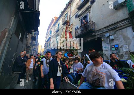 La statue de la Madonna delle Galline est portée en procession à travers les rues et est accueillie par les fidèles avec des fleurs, des offrandes de nourriture. Banque D'Images