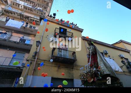 La statue de la Madonna delle Galline est portée en procession à travers les rues et est accueillie par les fidèles avec des fleurs, des offrandes de nourriture. Banque D'Images