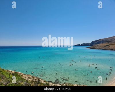 Plage publique avec eau turquoise, vue sur la magnifique baie avec de nombreux vacanciers dans l'eau de mer à Cala Mesquida sur Majorque, Espagne Banque D'Images
