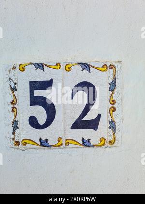 Un carreau de céramique avec le numéro de maison 52 sur un mur blanc, Majorque, Espagne Banque D'Images