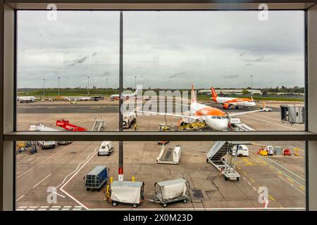 Une vue par la fenêtre à une porte de l'aéroport international de Birmingham à EasyJet Aircraft. Banque D'Images