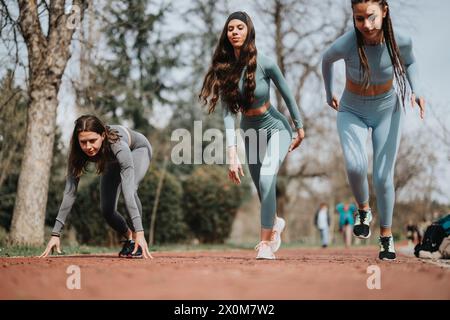 Trois amies féminines en équipement d'entraînement se préparant à courir dans le parc Banque D'Images