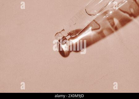 Plan macro du dropper de grall sur fond neutre avec espace de copie. Le compte-gouttes est rempli de sérum pour le visage. Fond cosmétique de soin de la peau Banque D'Images