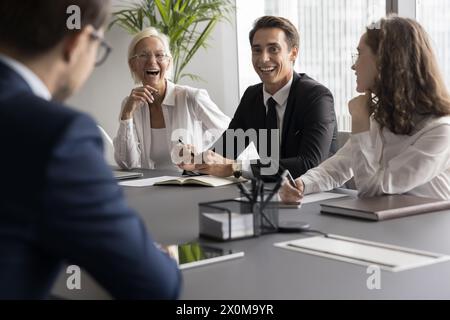 Les coéquipiers font du brainstorming, rient, partagent des anecdotes pour favoriser la cohésion d'équipe Banque D'Images