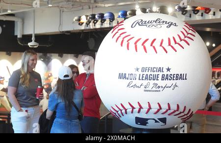 Maryland Heights, États-Unis. 12 avril 2024. Les visiteurs de la nouvelle ouverture du magasin Rawlings Experience sont créés par un baseball géant à Westport Plaza à Maryland Heights, Missouri, le vendredi 12 avril 2024. Le magasin est le premier magasin national pour Rawlings et a des chauves-souris, des balles et des gants à vendre, ainsi qu'un étalage de gants en or de ceux qui ont remporté le prix depuis 1958. Le prix est décerné à certains des plus grands joueurs défensifs du jeu. Photo de Bill Greenblatt/UPI crédit : UPI/Alamy Live News Banque D'Images