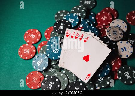 Disposition des cartes avec la quinte royale sur les jetons sur la table verte dans le casino Banque D'Images