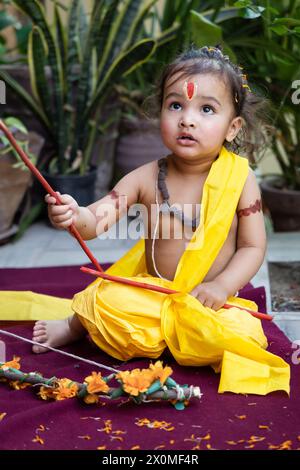 Portrait de mignon garçon indien robes comme seigneur rama avec arc à l'extérieur avec fond flou le jour Banque D'Images