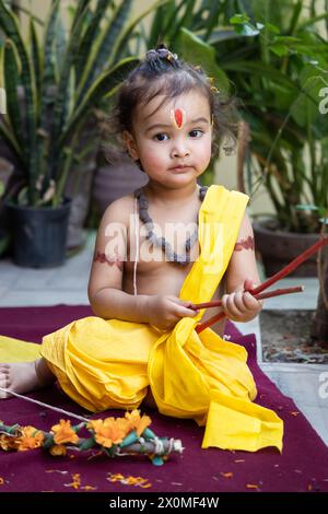 Portrait de mignon garçon indien robes comme seigneur rama avec arc à l'extérieur avec fond flou le jour Banque D'Images