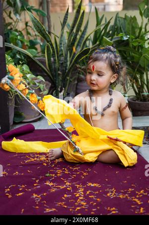 Portrait de mignon garçon indien robes comme seigneur rama avec arc à l'extérieur avec fond flou le jour Banque D'Images