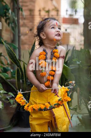 Portrait de mignon garçon indien robes comme seigneur rama avec arc à l'extérieur avec fond flou le jour Banque D'Images