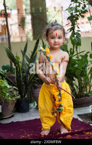 Portrait de mignon garçon indien robes comme seigneur rama avec arc à l'extérieur avec fond flou le jour Banque D'Images