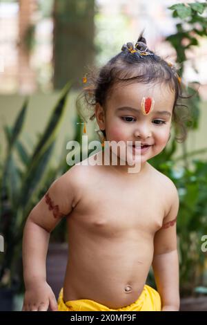 Garçon indien mignon avec symbole religieux sacré sur la tête à l'extérieur avec fond flou Banque D'Images