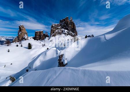 Snowdrift créant des structures artistiques en hiver, les pentes enneigées du paysage alpin Dolomite et les sommets du groupe Cinque Torri au loin Banque D'Images