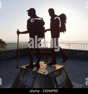 Pèlerin de Montefiascone monument au coucher du soleil sur la via Francigena avec le lac Bolsena derrière, province de Viterbe, région du Latium, Italie. Avril 2024 Banque D'Images